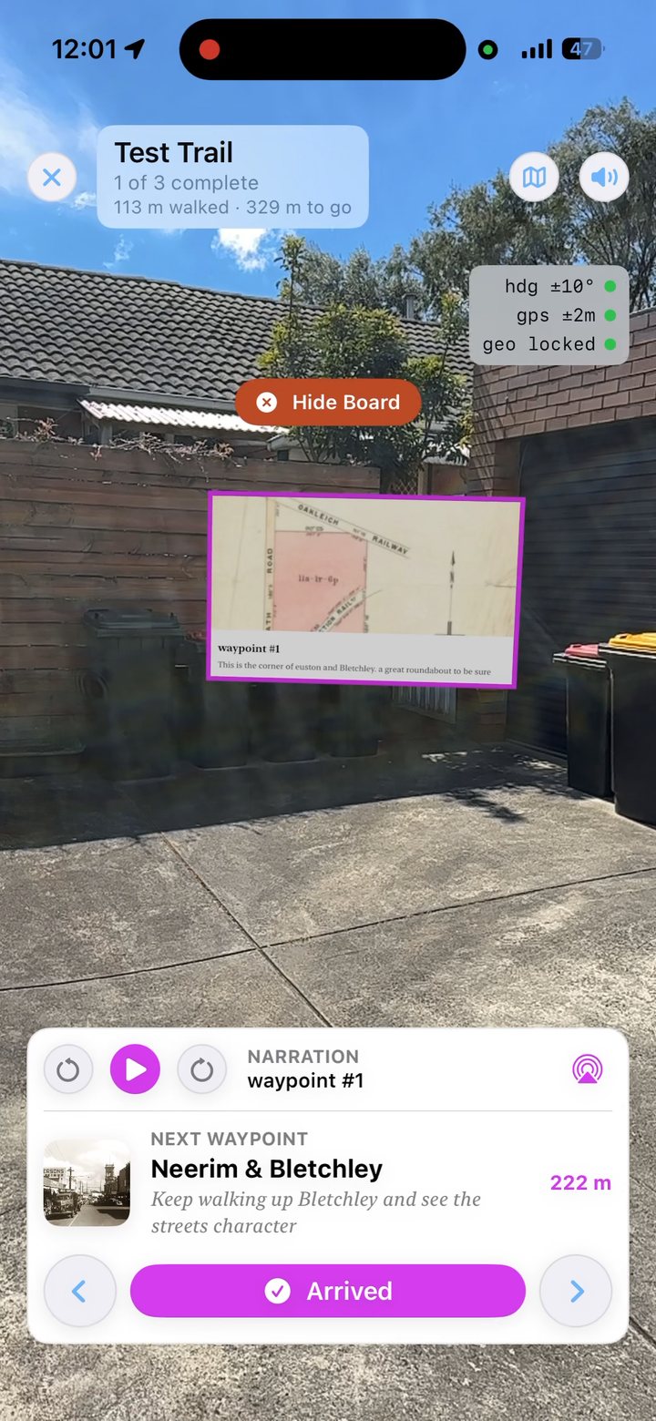 AR view on iPhone: a notice board with an old map on it, floating in a suburban driveway beside a brick wall, with a Hide Board button above.